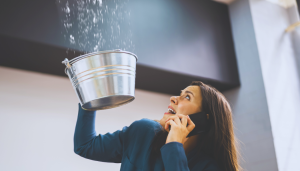 Frau fängt mit Eimer Wasser auf