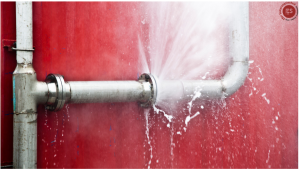 Rohrbruch Wasser spritzt raus rote Wand